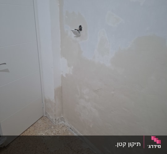 עבודת תיקון טיח ושפכטל בקיר פנימי לפני צביעה